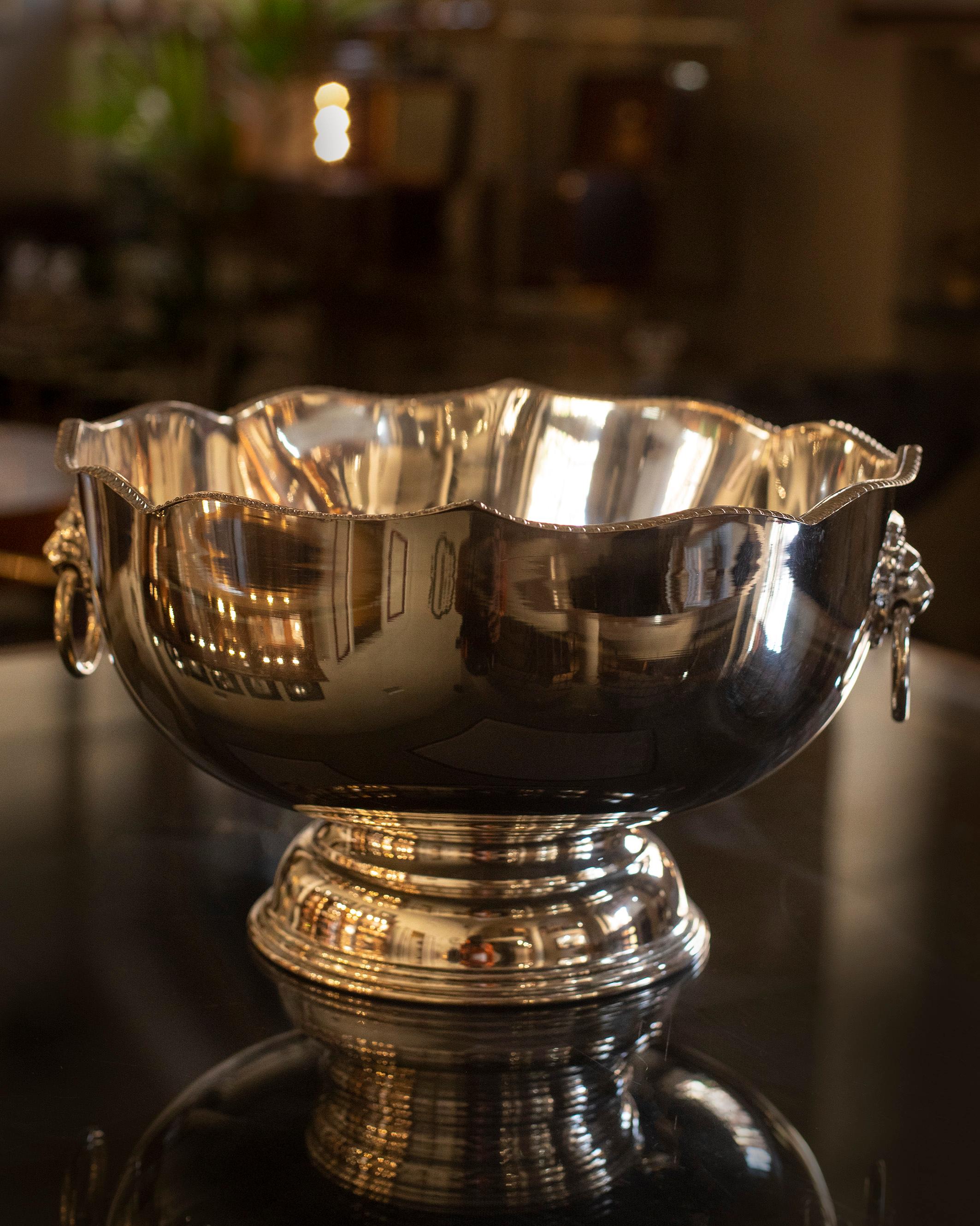 Dieser englische Champagnerkübel aus der Mitte des zwanzigsten Jahrhunderts aus Silber und Kupfer zeigt auf jeder Seite einen Löwenkopf mit einem Henkel mit Tropfenring. 

Eine stilvolle Art, Ihren Champagner perfekt kühl zu halten.