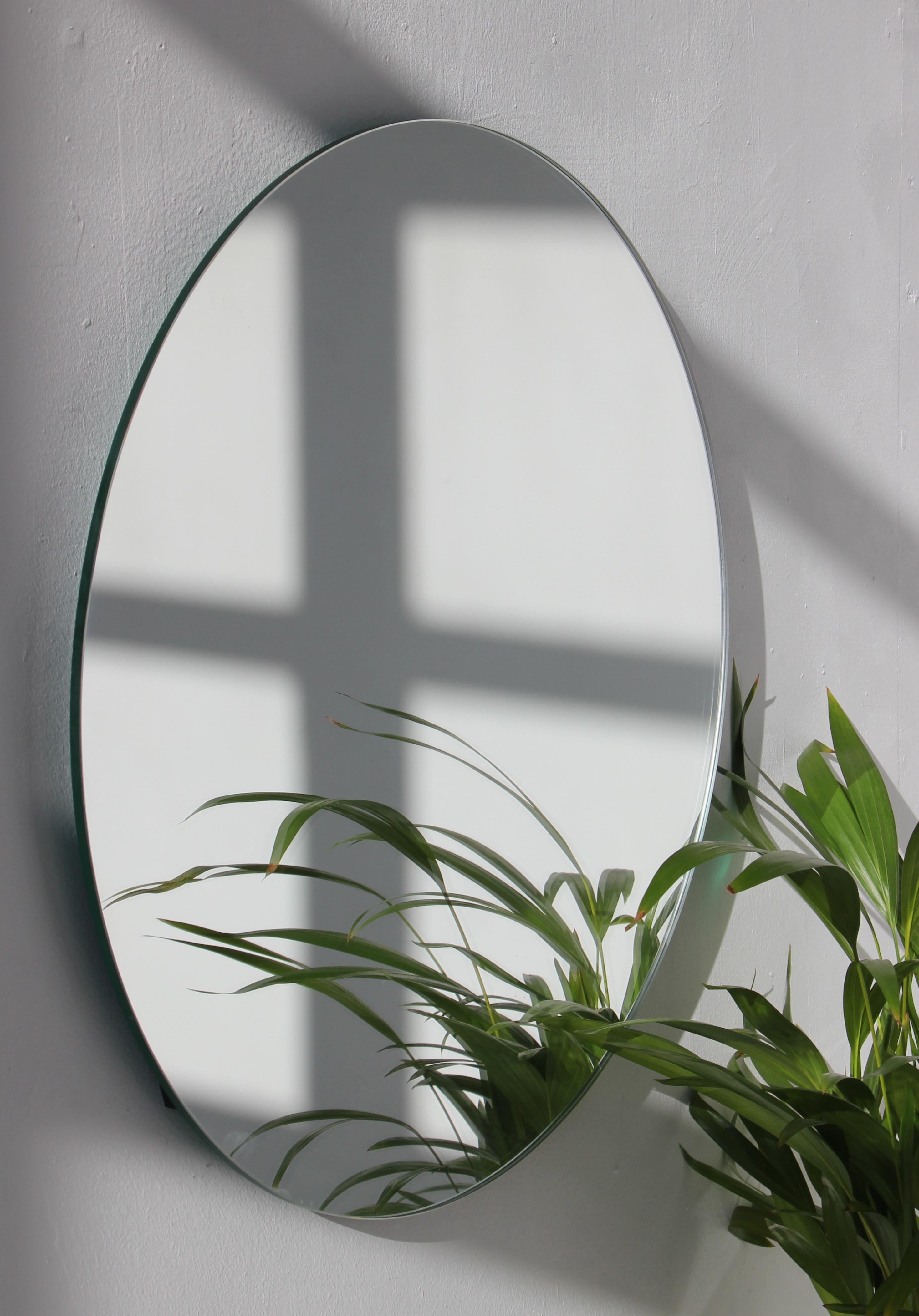Minimalistischer runder rahmenloser Spiegel mit Schwebeeffekt. Hochwertiges Design, das dafür sorgt, dass der Spiegel perfekt parallel zur Wand steht. Entworfen und hergestellt in London, UK.

Ausgestattet mit professionellen Platten, die im