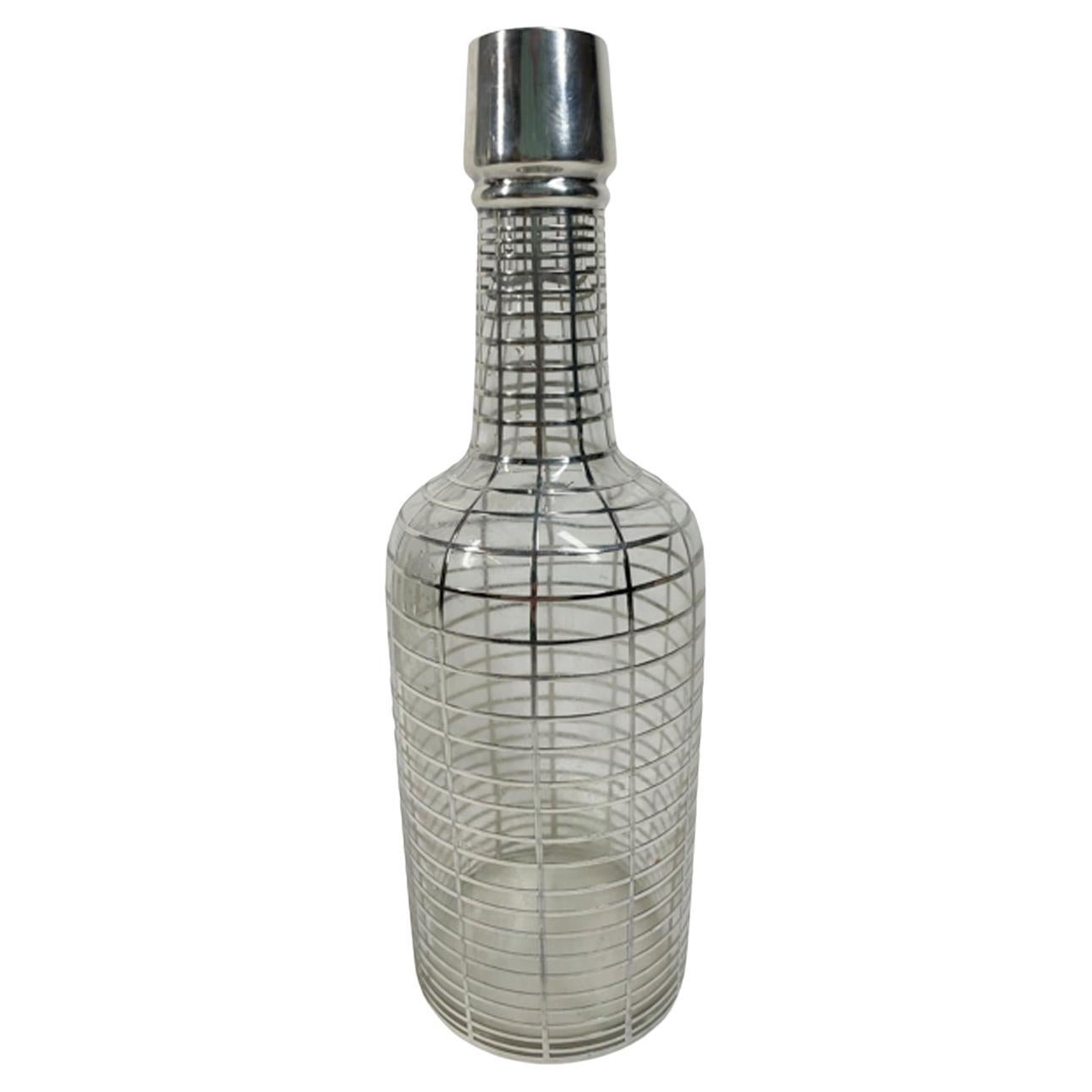 Early 20th century silver overlay clear glass back bar bottle with narrow sterling rings spaced evenly from top to bottom with vertical lines connecting the rings. A rectangular panel just below the shoulder is engraved with a script 