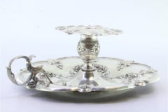 Silver paddle w/ raised floral motifs & acanthus leaf applications on the handle
