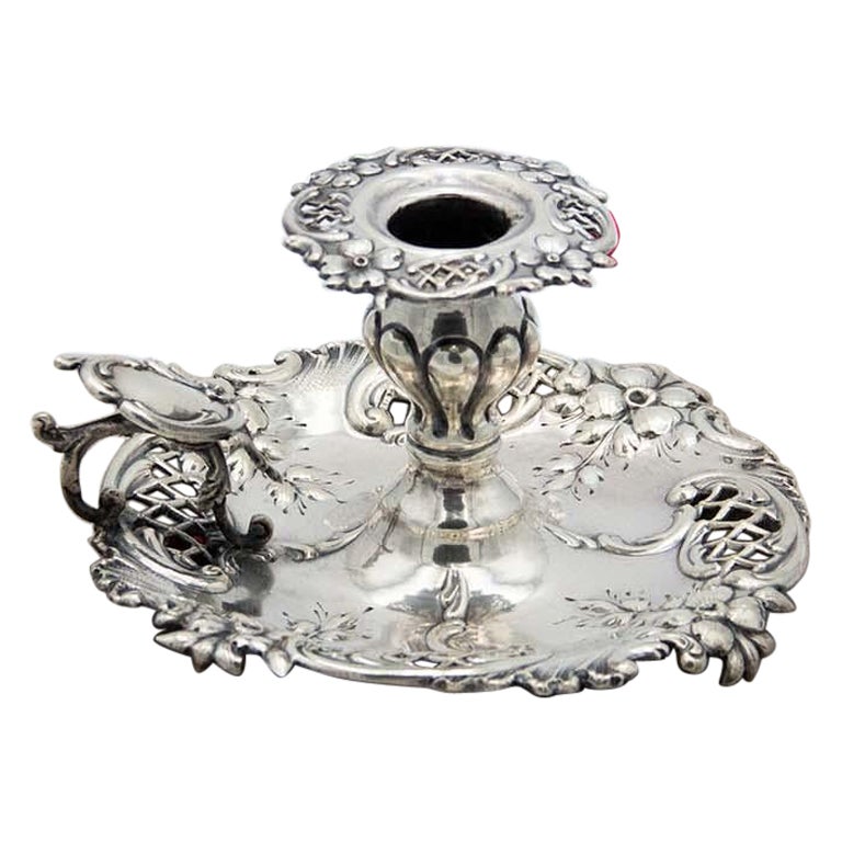 Silver paddle with embossed floral motifs and a monogrammed card on the handle