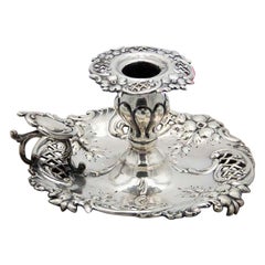 Silver paddle with embossed floral motifs and a monogrammed card on the handle