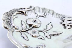 Silver paddle with embossed floral motifs and applications
