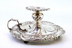 Silver paddle with embossed florals, corded edge, and three feet