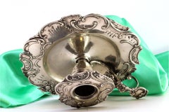 Silver paddle with embossed florals, cutout surround, and monogram handle