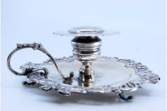 Silver paddle with embossed flowers and set on three feet