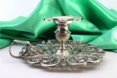 Silver paddle with floral motifs and a smooth handle