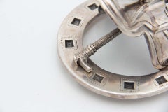 Silver paddle with horseshoe, peg and horse saddle