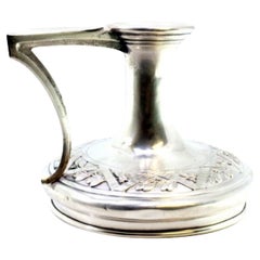 Silver paddle with raised floral motifs in the circular shape