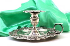 Silver paddle with revealed floral motifs and rolled handle