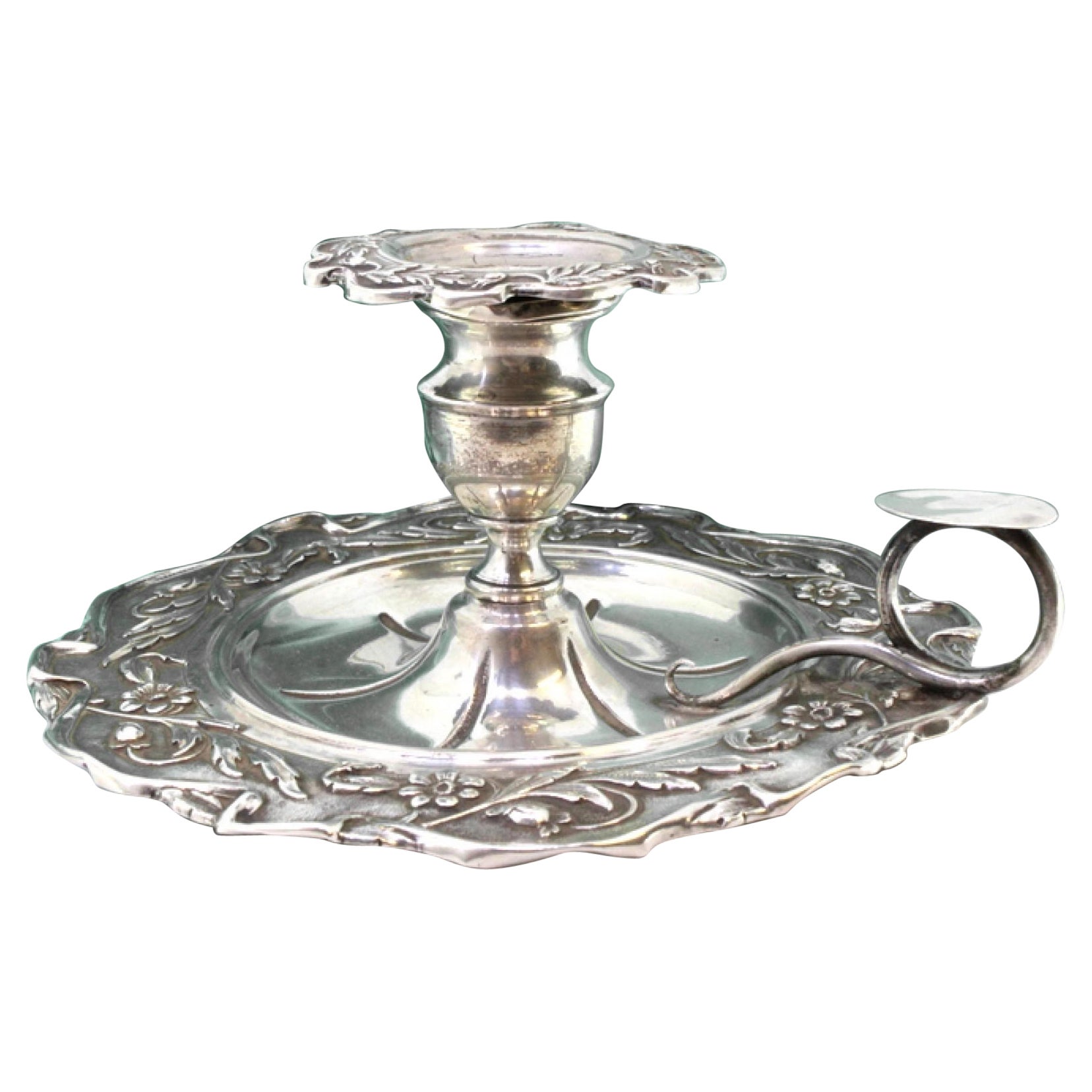 Silver paddle with revealed floral motifs and rolled handle