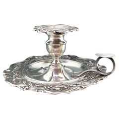 Silver paddle with revealed floral motifs and rolled handle