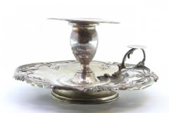 Silver paddle with trimmed edges and placed on a circular base