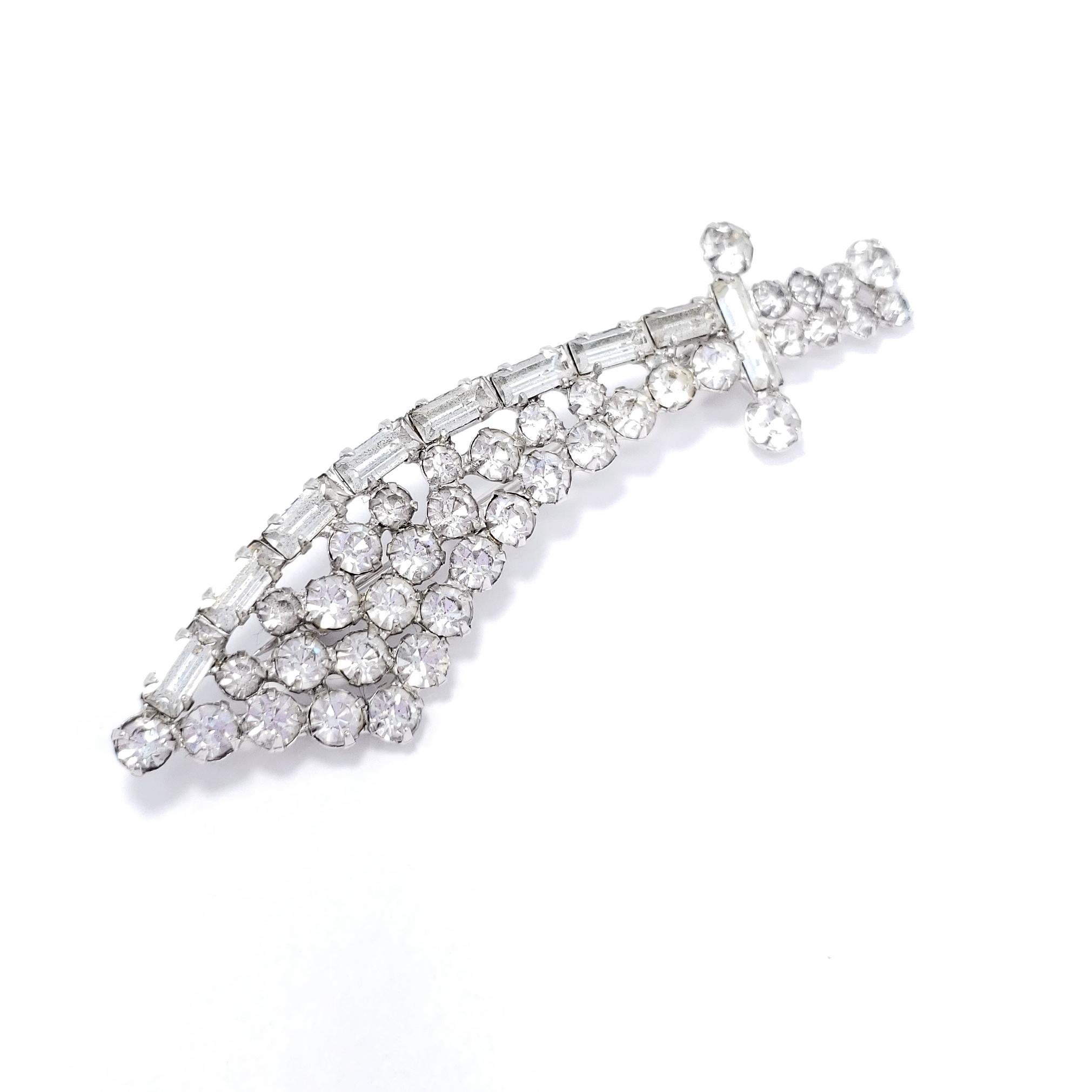 A dazzling saber pin, decorated with sparkling clear crystals! Silver tone.

Hallmarks: n/a