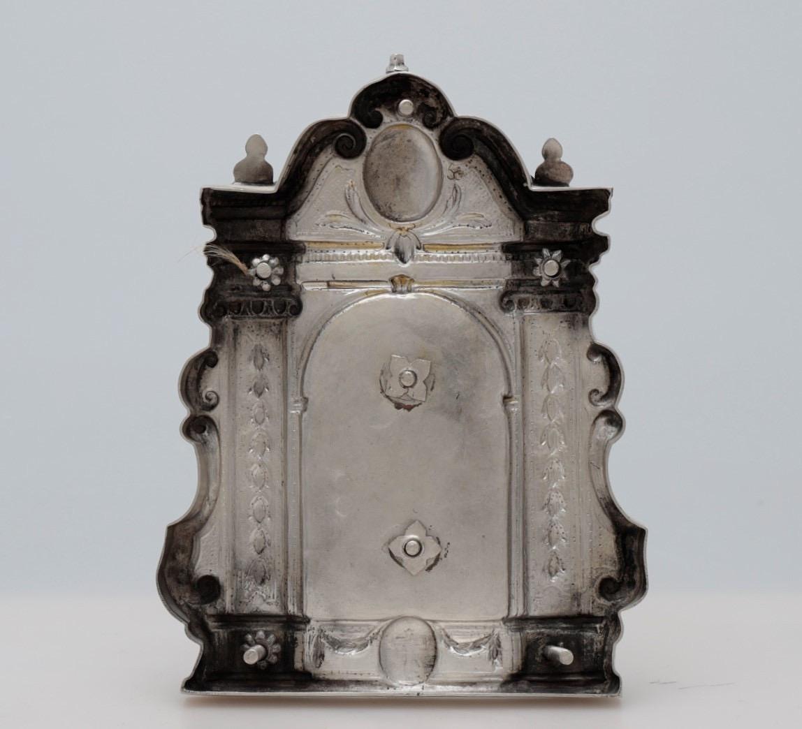 Portapaz. Silver in its color. Manuel Aguilar and Diego de la Vega, Córdoba, 1816.
With contrast marks.
Portapaz made of silver in its color with an architectural distribution of a pedestal with garlands and a shield with a Latin cross in the