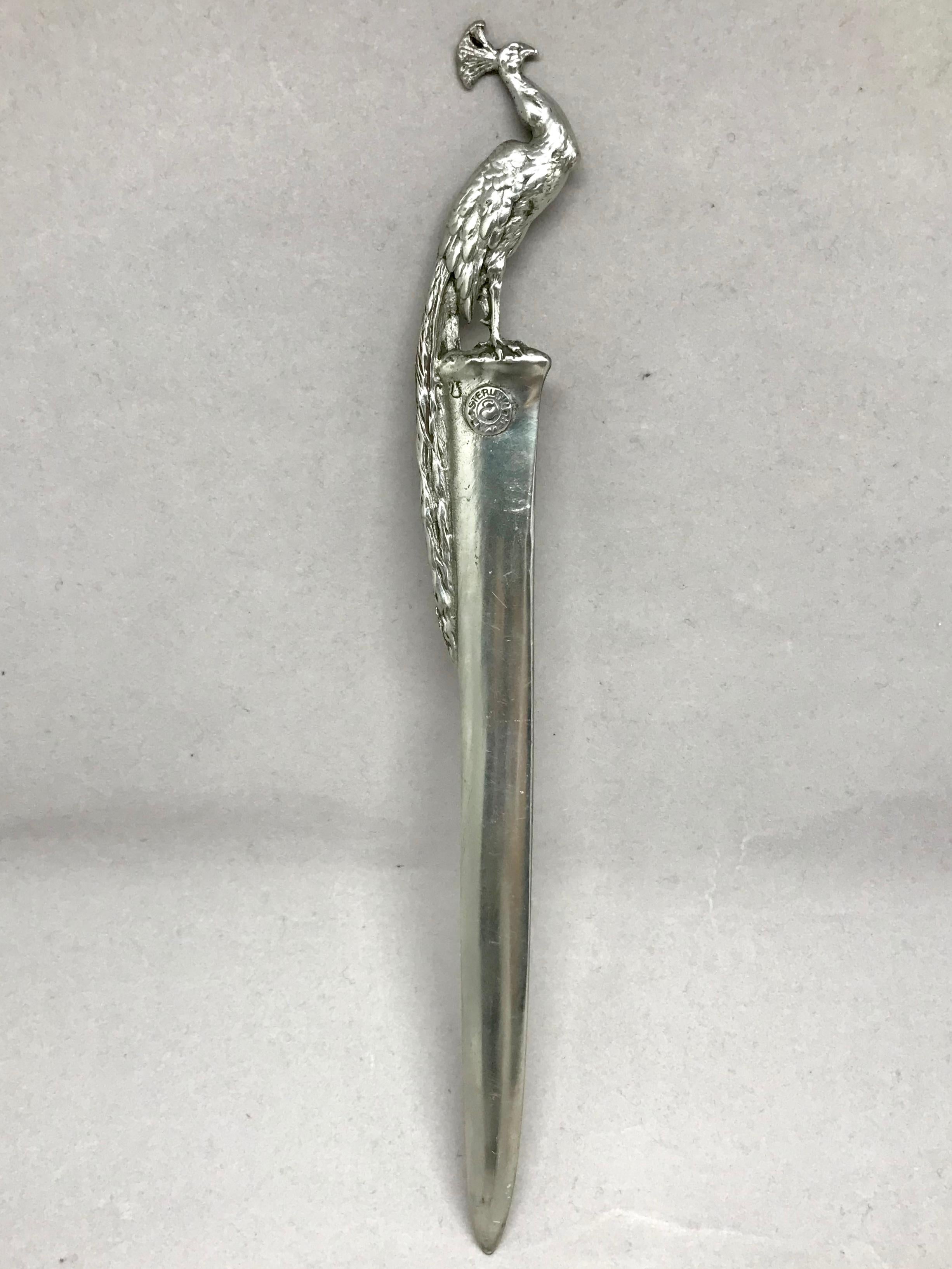 Silver peacock letter opener. Vintage silvered pewter letter opener with peacock stamped E. United States, 1940s.
Dimensions: 9.38
