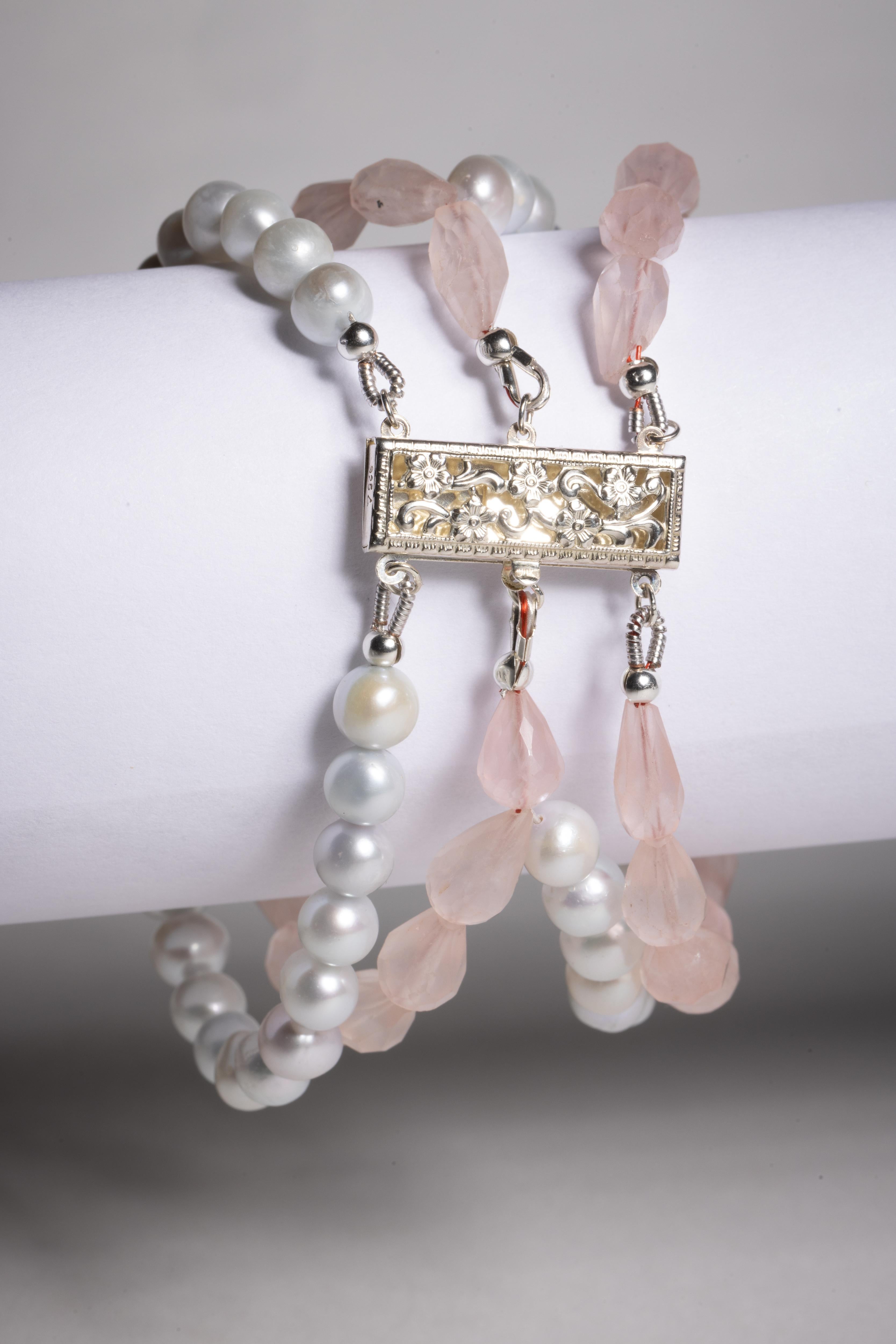 Un insolito bracciale a più fili con perle tonde d'argento alternate a perle di quarzo rosa sfaccettate e a forma di pera.  Un'ampia chiusura a pressione in filigrana in argento sterling.

La collezione di alta gioielleria è stata acquistata,
