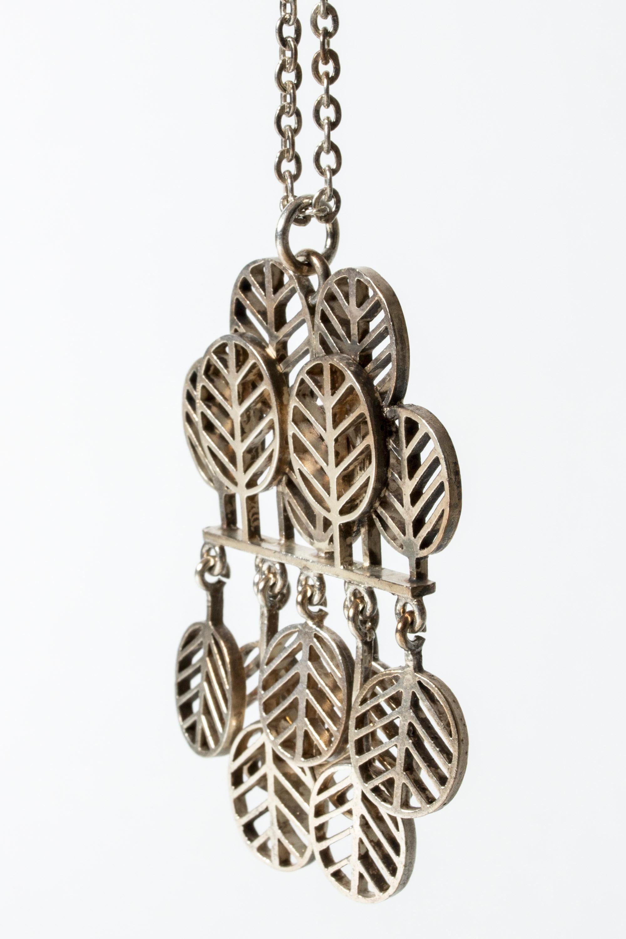 Striking, kinetic silver pendant by Jorma Laine, in a design of stylized leaves. Nice movement in the loosely hanging, downward turned leaves.