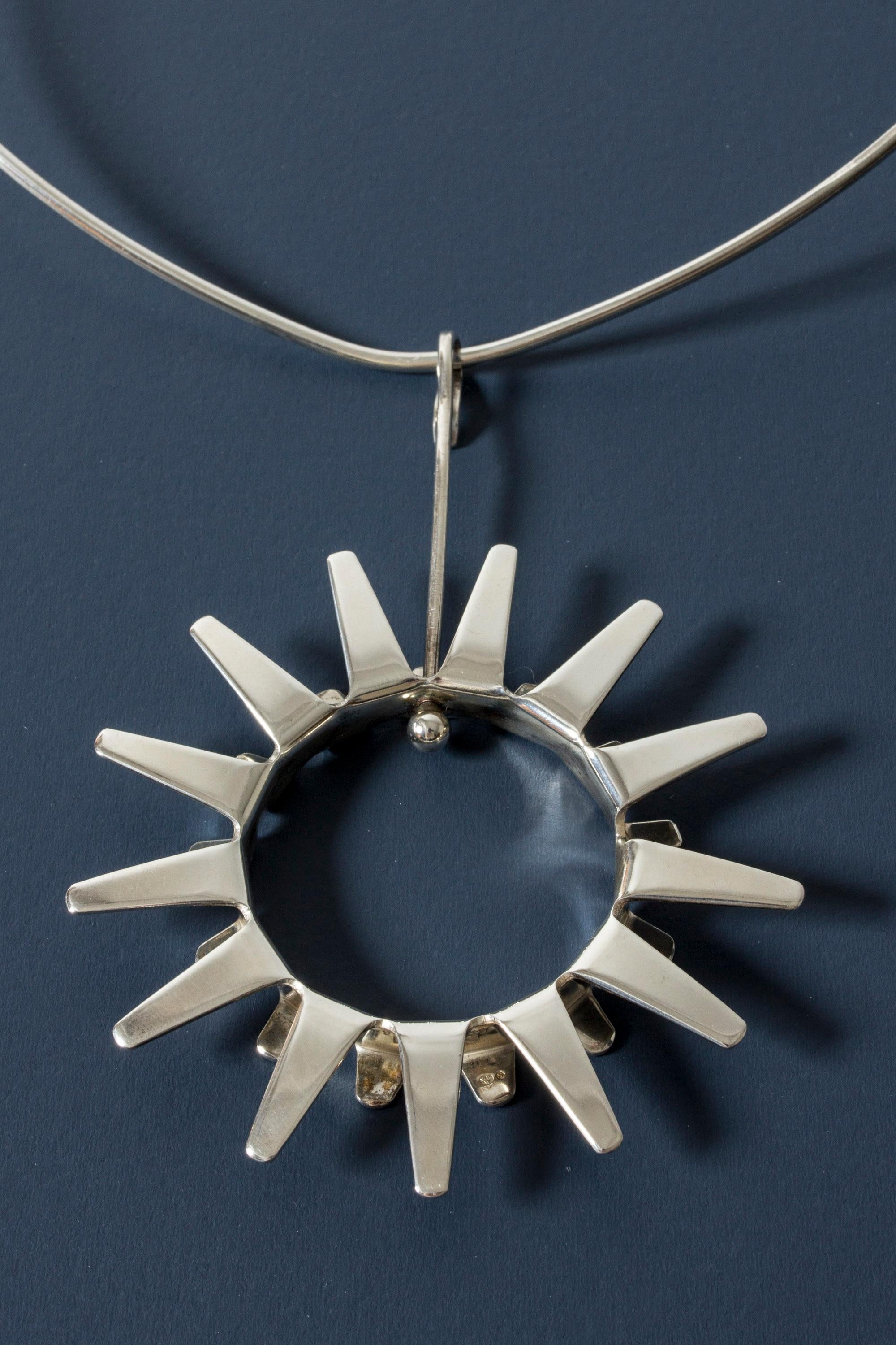 Amazing silver neckring by Tone Vigeland, with a large stylized pendant in the form of a sun. Vivacious and graphic, a very expressive design.

Dimensions: Inner width of neckring 13.2 cm, height pendant 9.2 cm, width of pendant 6.5 cm