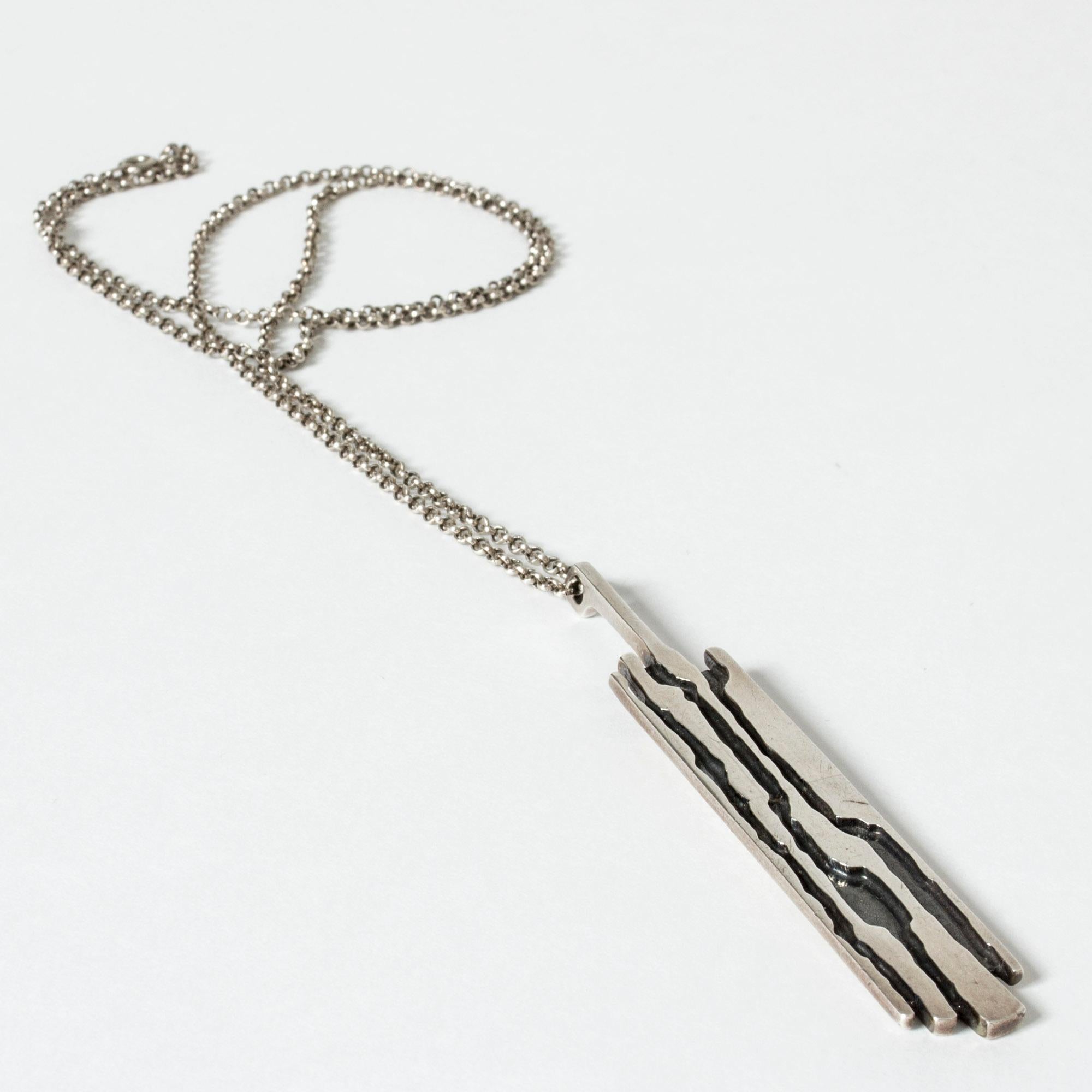 Edgy silver pendant from Niels Erik From with a design like styleized tree bark. The pendant is partially blackened to give it depth.
