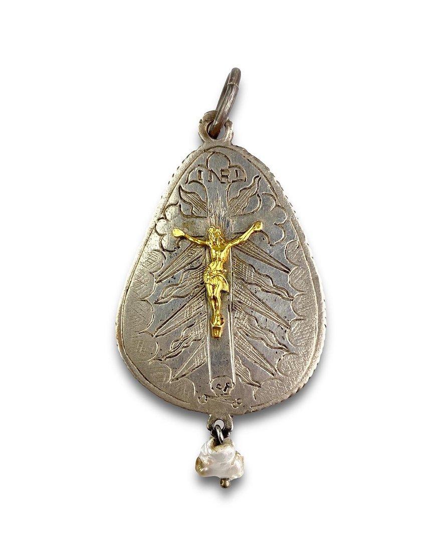 Silver Pendant with Mother-of-Pearl Cameo of the Virgin and Child
 
German, mid-15th century
 
Silver, parcel-gilt, mother-of-pearl, baroque pearl
Measurements: total height 7 cm
 
A devotional pendant of tear-shaped form, set with a carved