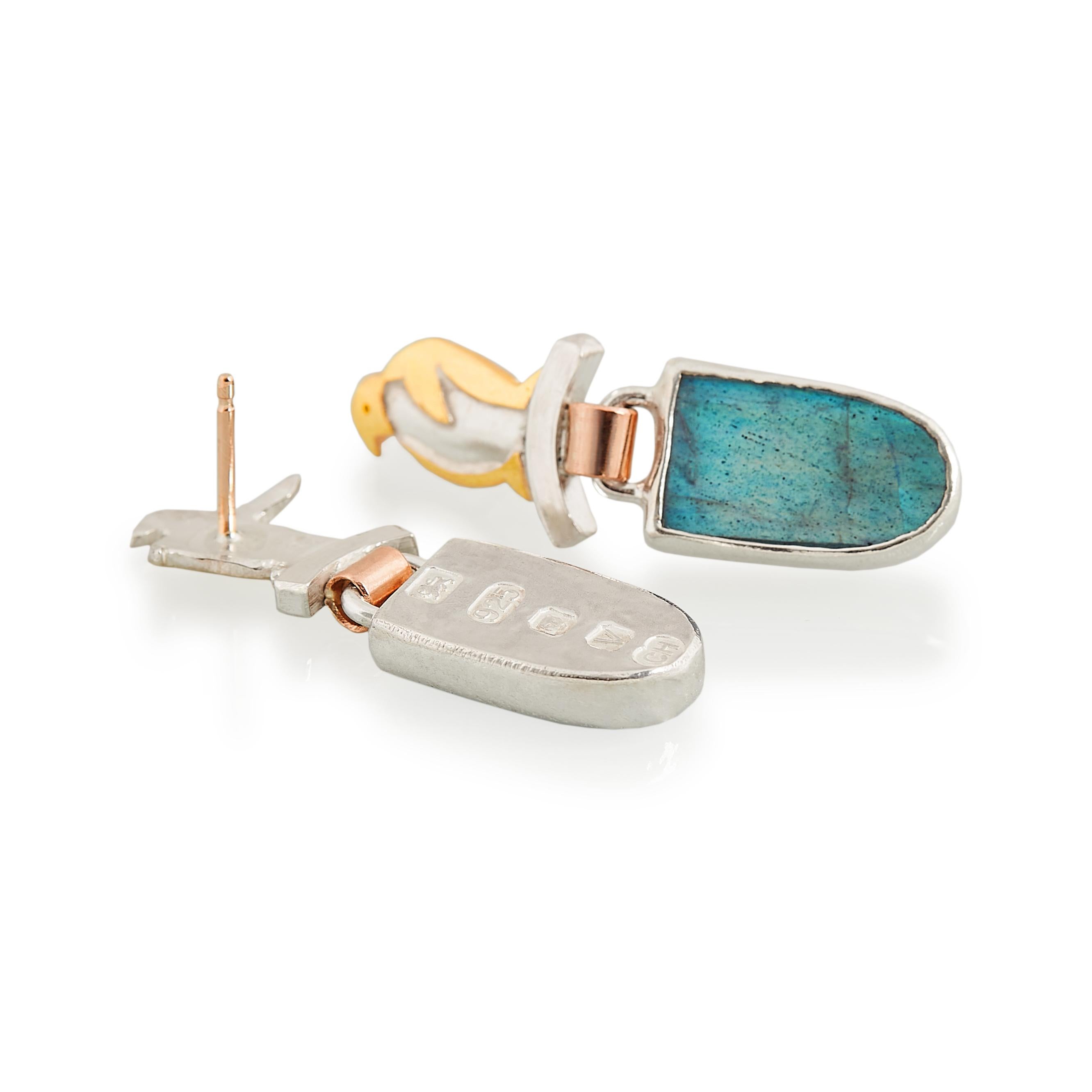 Charming sterling silver penguin drop earrings with 22 karat gold details and 9 karat gold links and posts for people with sensitive ears. The stones are labradorite which have a beautiful light blue flash. They are stamped on the backs with large