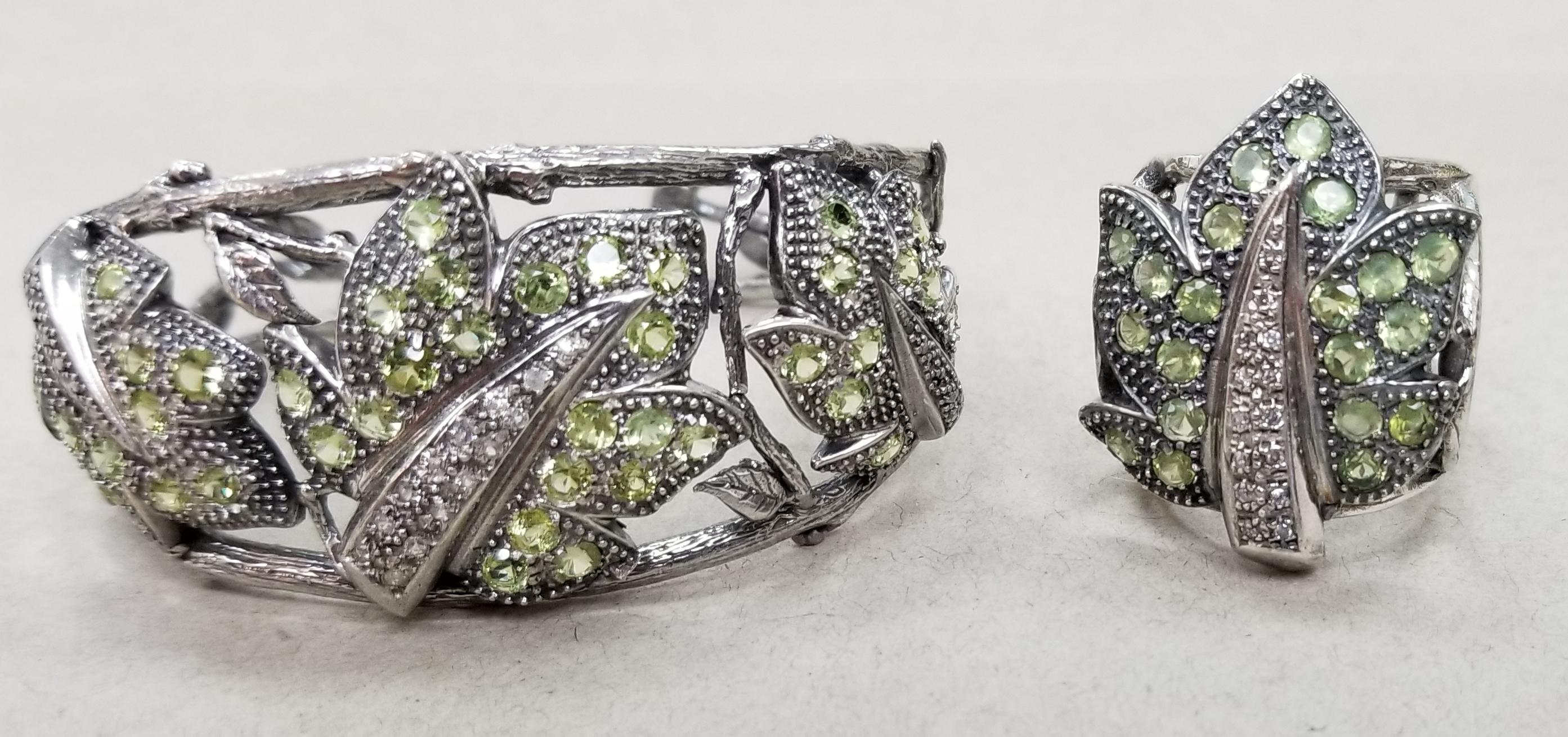 Gresha signature bark finish leaf cuff and ring.  Cuff has 40 round peridot weighing 4.25cts. and 13 white sapphires weighing .35pts. in a leaf antiqued finish.  The ring can be worn both as a size 6+ or an 8+, it has 20 peridot weighing 2.55cts.