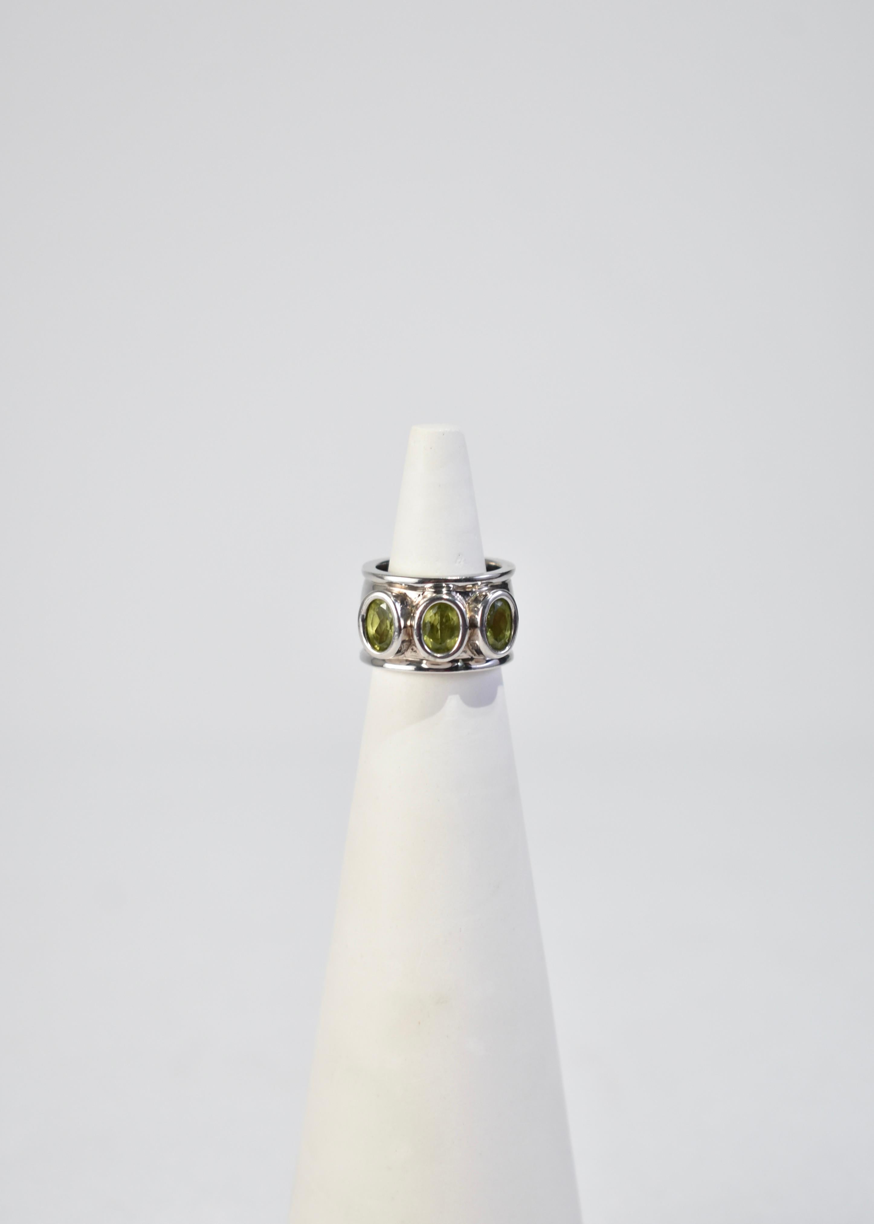 Vintage silver ring with three faceted peridot stones, stamped 925.

Material: Sterling silver, peridot.