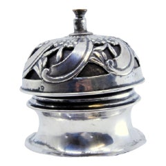 Silver pierced bell with spiral floral motifs and interior mechanism