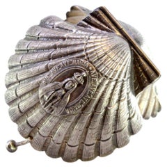 Silver pill box in the shape of a shell with reliefs and application for opening