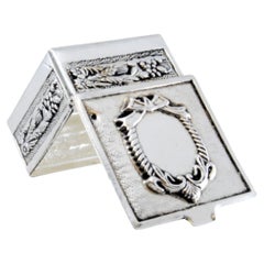 Silberne Pillendose mit Schleifen und Reliefs auf dem Rand und Scharnierdeckel