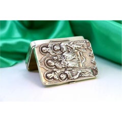 Silver pill box with embossed figures revealed on the lid