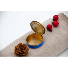 Silver pill box with enamel floral motifs, gold interior and hinged lid
