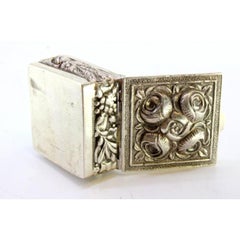 Silver pill box with floral motifs revealed on the lid and application