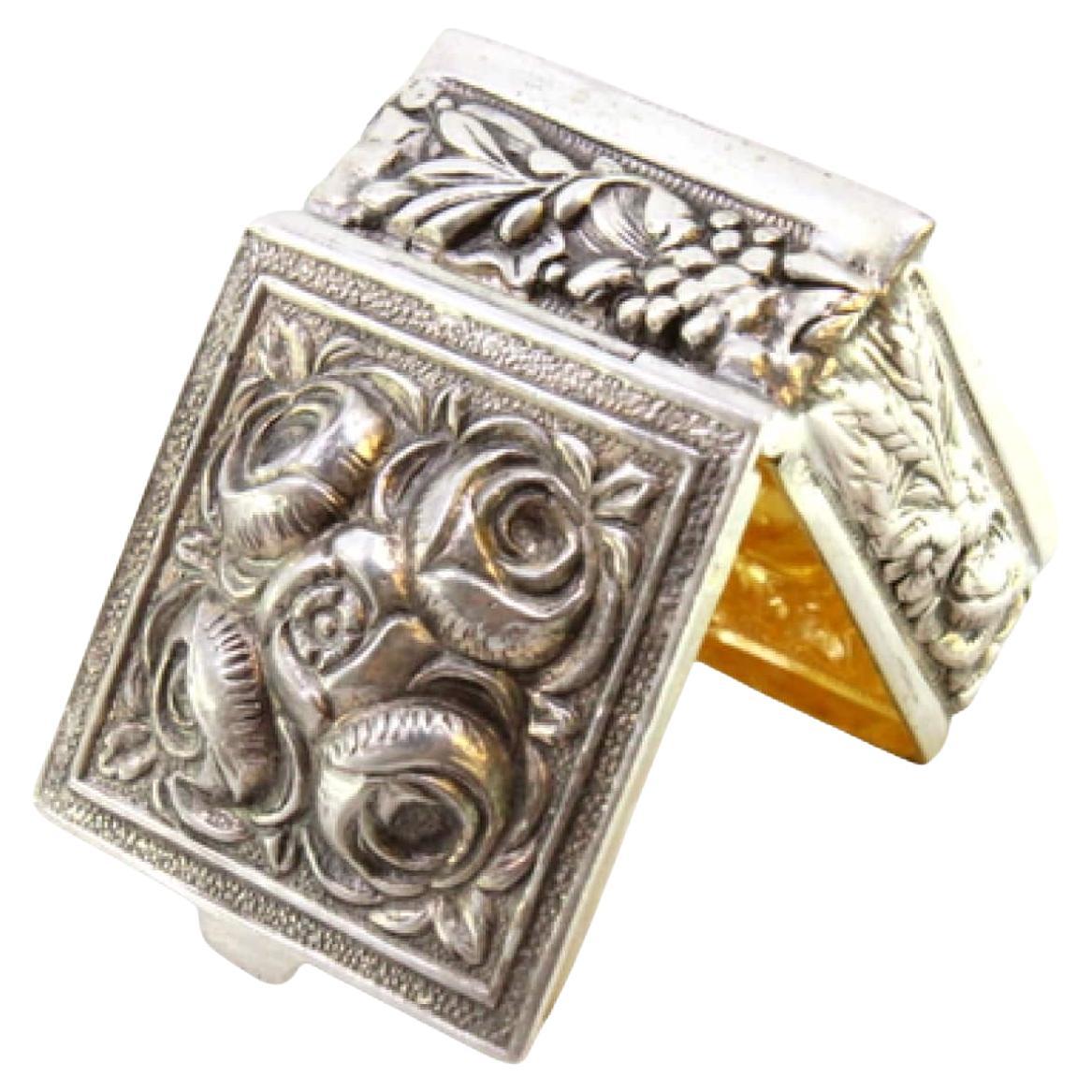 Silver pill box with floral motifs revealed on the lid and application