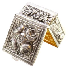 Silver pill box with floral motifs revealed on the lid and application