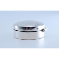 Silver pill box with reliefs on both sides of the hinged lid