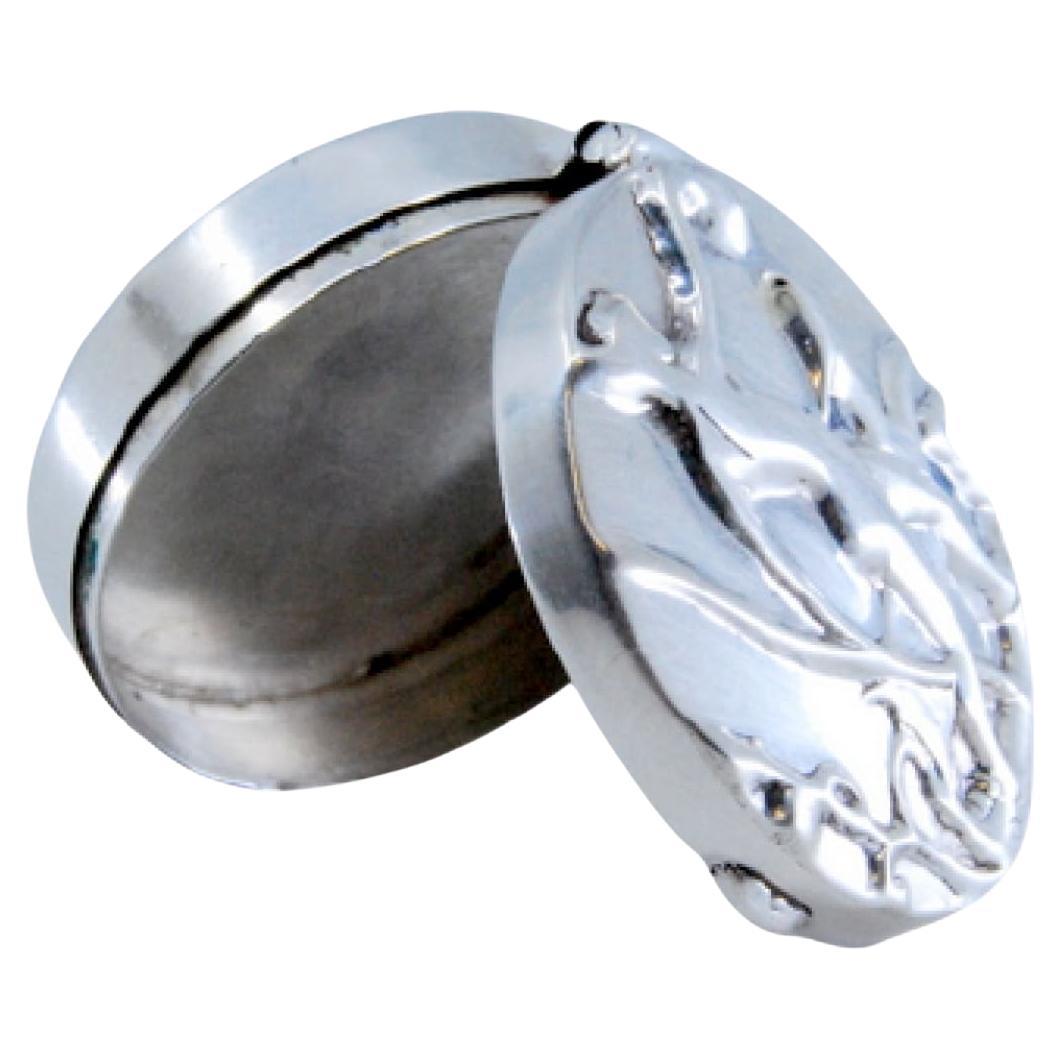 Silver pill box with reliefs on the hinged lid