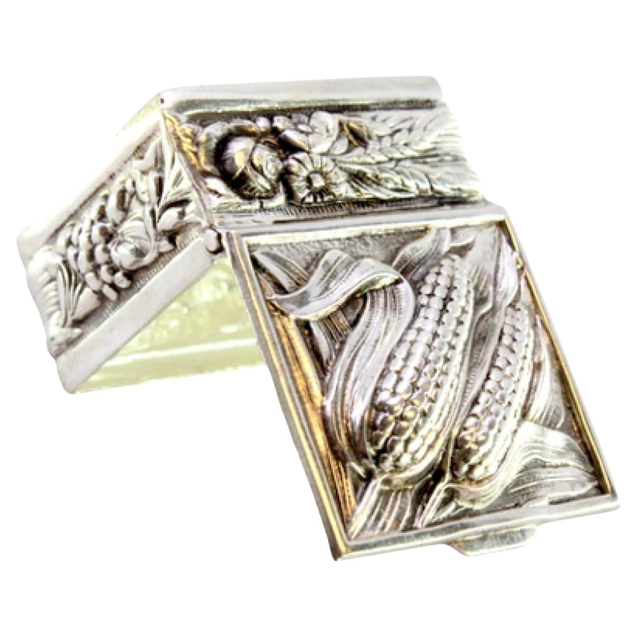 Silver pill box with two embossed lumps on the lid