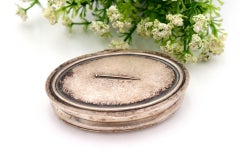 Silver pin box with elliptical-shaped friezes and relief