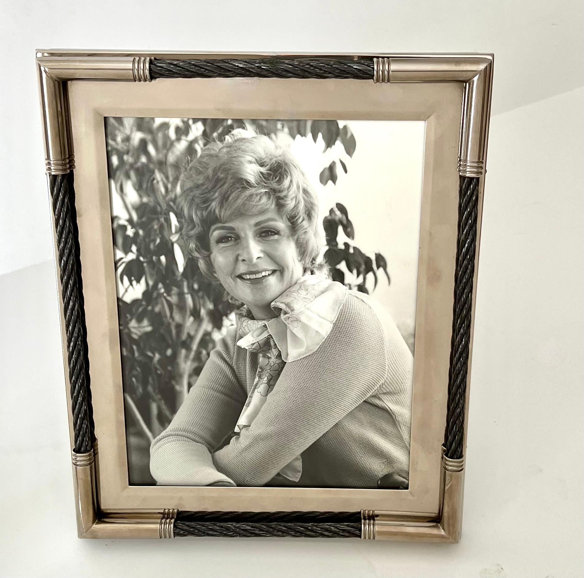 A silver plate frame for 8 x 10 photos. The piece is unique in that it uses woven twisted wire as an accent and it looks very luxurious. The sliver is in very good overall condition and is polished. The piece sits on a standard photo stand that