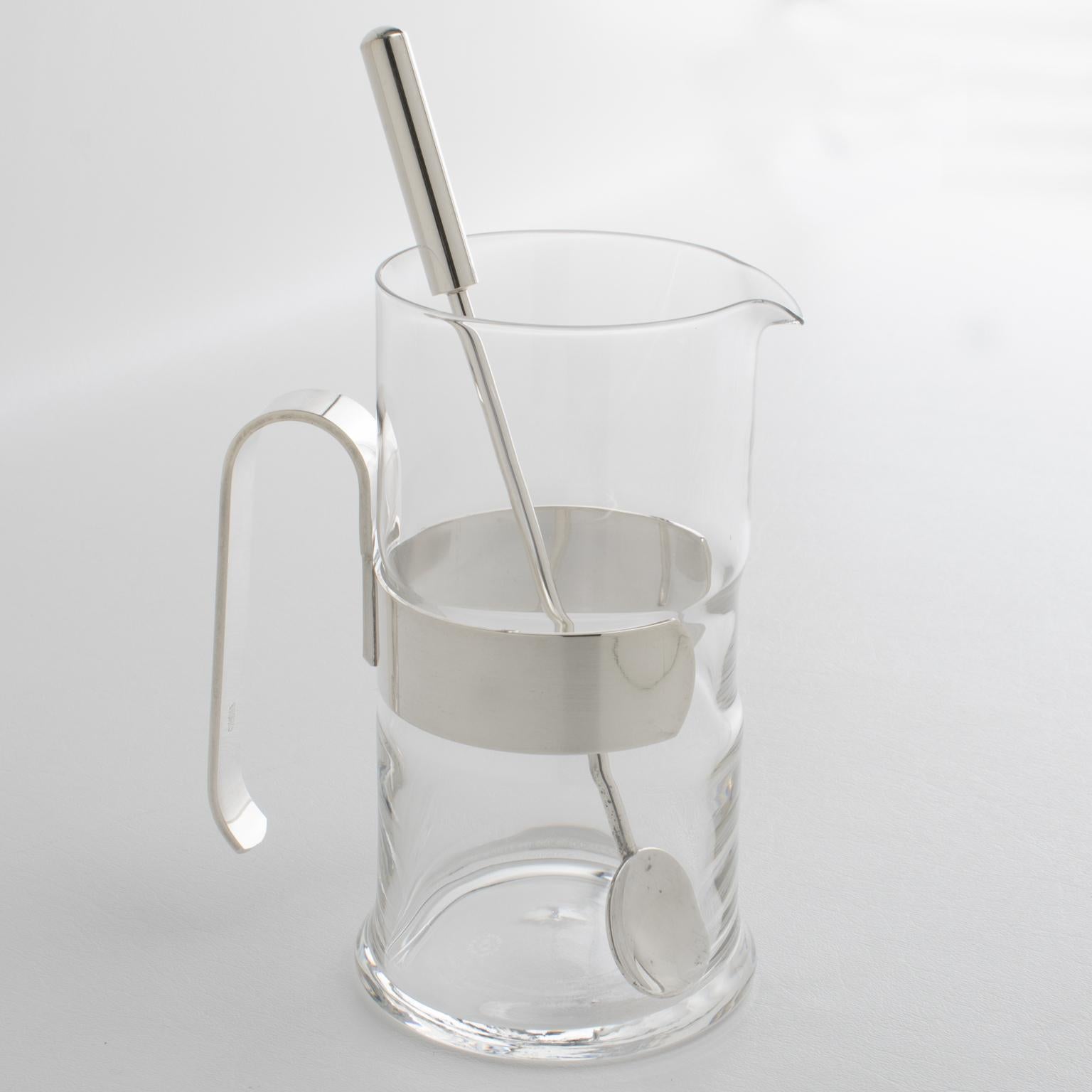 Empresa italiana de orfebrería P.M. Italia diseñó esta lujosa jarra modernista de cristal y plata para Martini o cóctel hacia 1980. El diseño minimalista y chic tiene una forma redonda con un recipiente de cristal, un marco de metal plateado con un