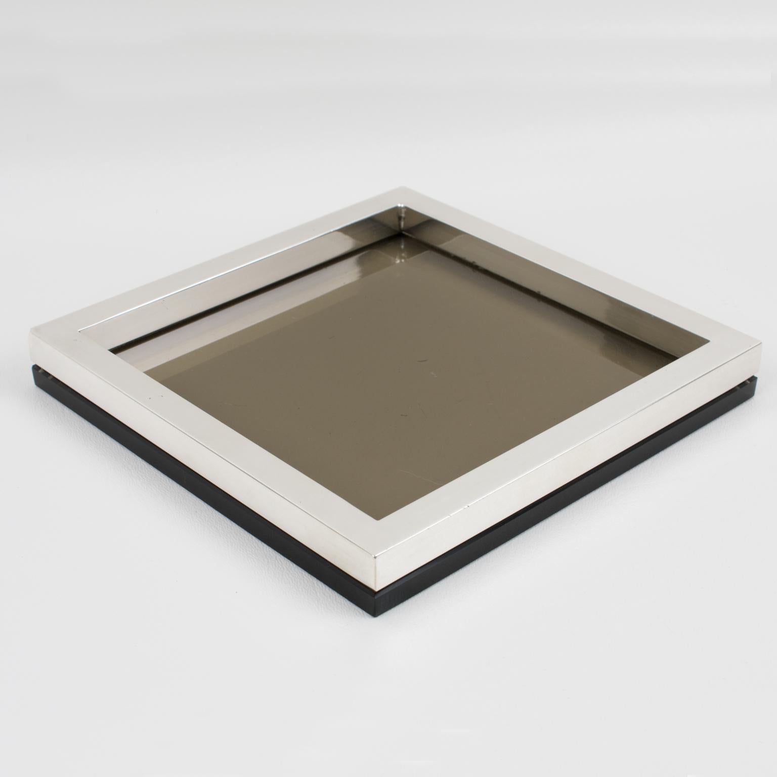 This elegant Mid-Century silver plate and glass tray, catchall or vide poche, was designed by silversmith R. Debladis, Paris, in the 1970s. The centerpiece boasts a square shape with a streamlined design featuring a silver-plated metal gallery and a