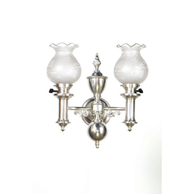 Argand style silver plated sconces with the original glass shades. One shade has a crack that has been professionally sealed, as pictured. C. 1910. – sold as a pair, two sets available.

Dimensions: 
Height: 15
Width (Diameter): 15.
