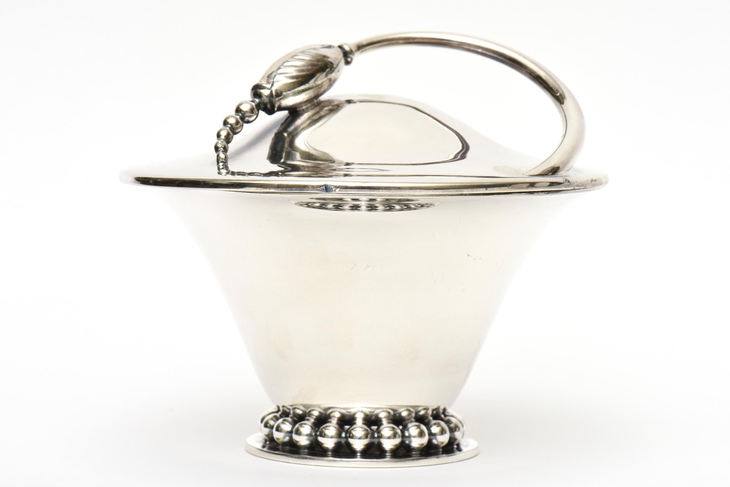 This lovely vintage 1960's covered vessel, bowl and or serving piece is silver-plate. It has a base of beaded balls and the lid is a flower pod design with a swirled stem. This is both in the style of Napier and Georg Jensen from Denmark.  It is