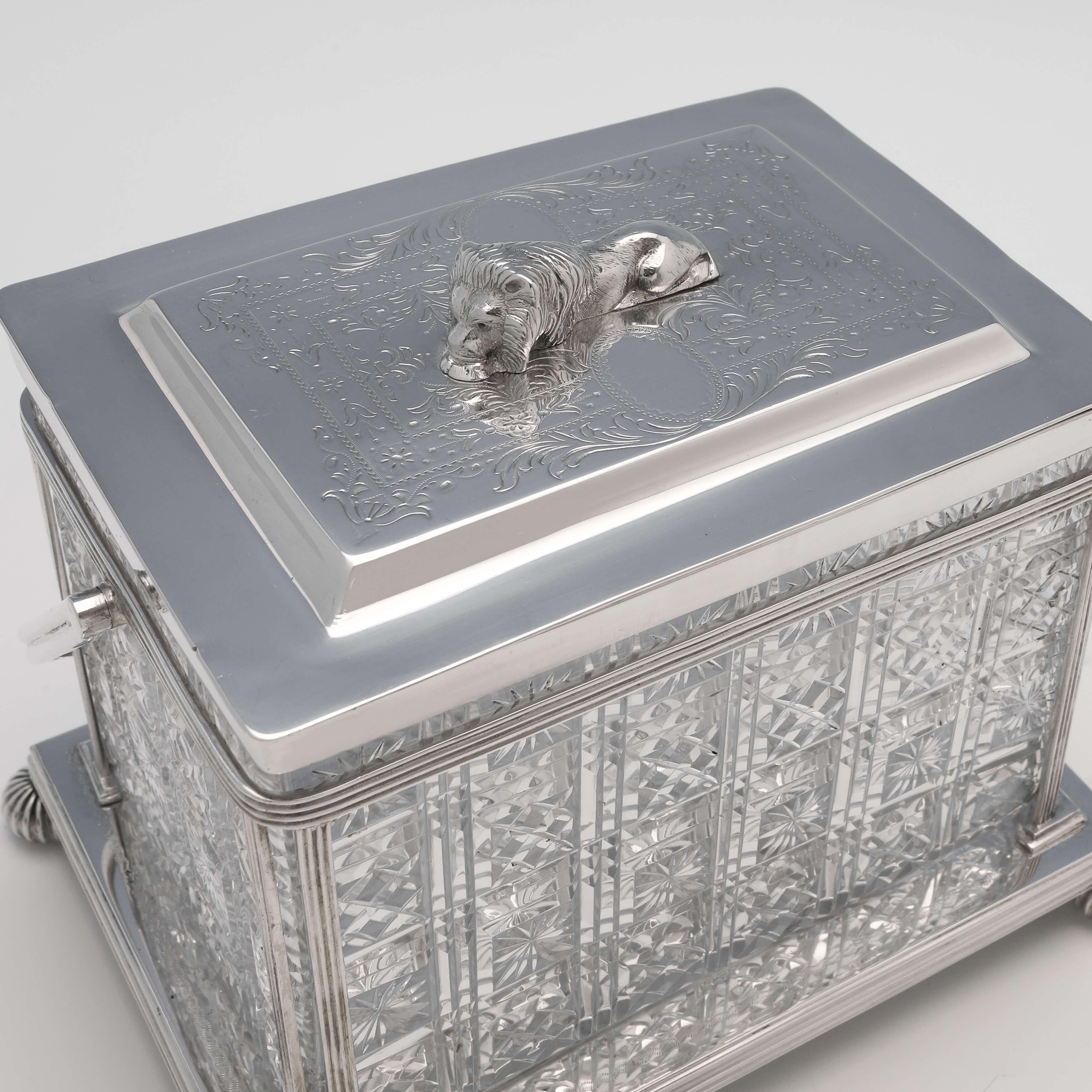 Made circa 1880 by Cooper Brothers & Sons, this attractive, Victorian, antique silver plate biscuit box, is rectangular in shape, and features a cut class body, engraved decoration to the lid, and a recumbent lion finial. The biscuit box measures