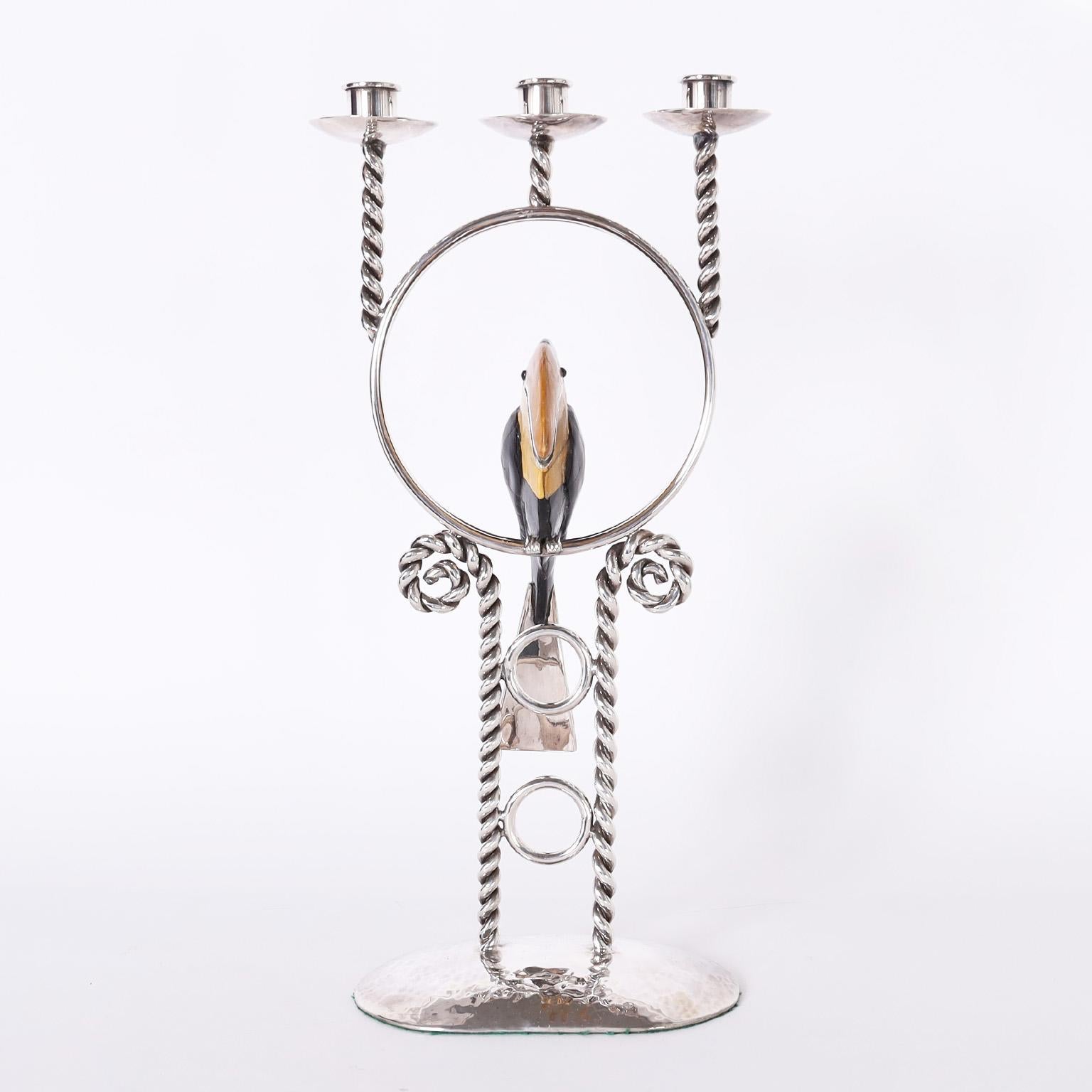 Rare and remarkable whimsical candelabra crafted in silverplate over copper by master silversmith Emllia Castillo with three candle cups over twisted supports featuring a perched toucan clad in stone on a base with twisted supports on a hammered