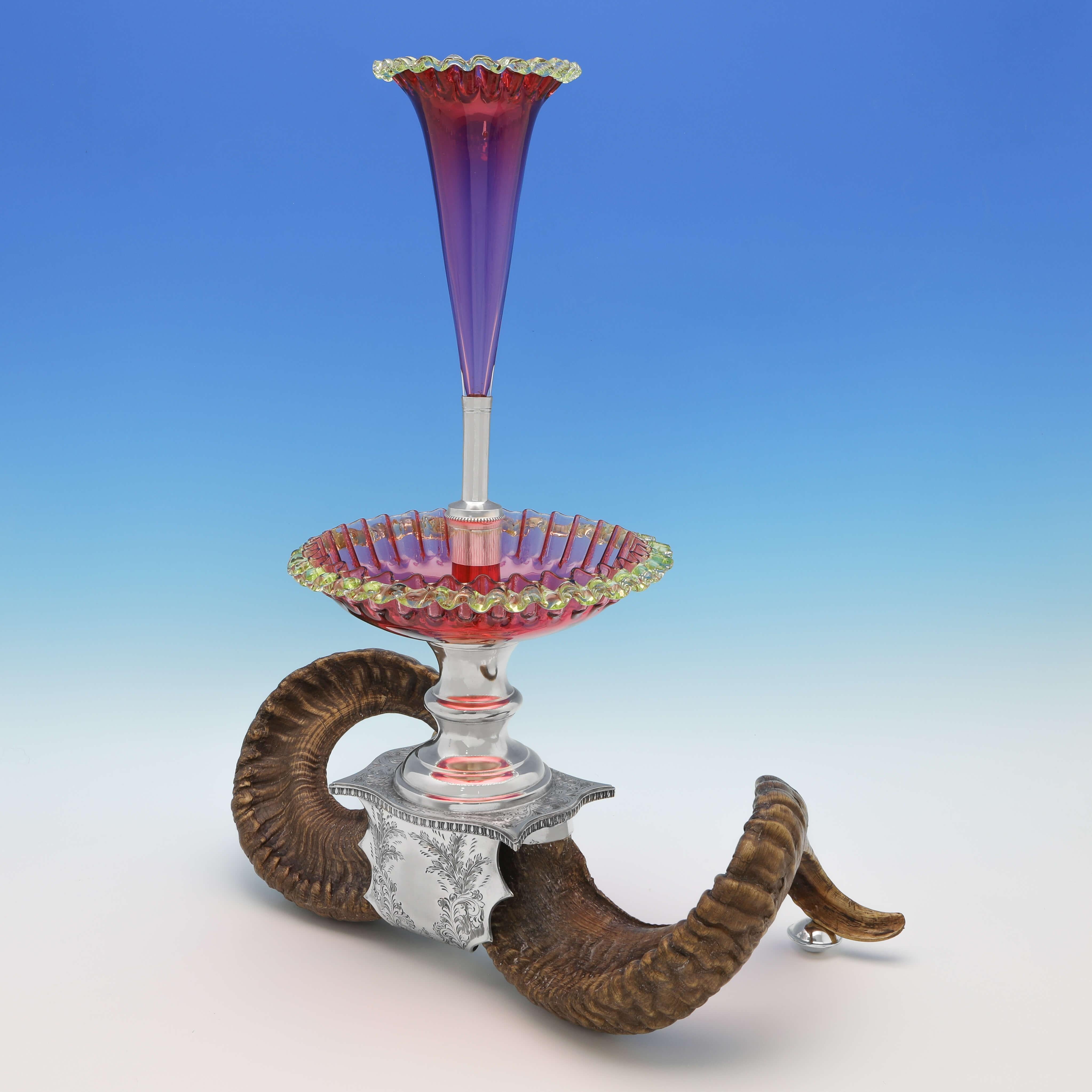 Made circa 1880, this striking, Victorian, antique silver plated centrepiece, stands on Ram horn legs, and features a varicoloured glass dish and trumpet vase. The centrepiece measures 22