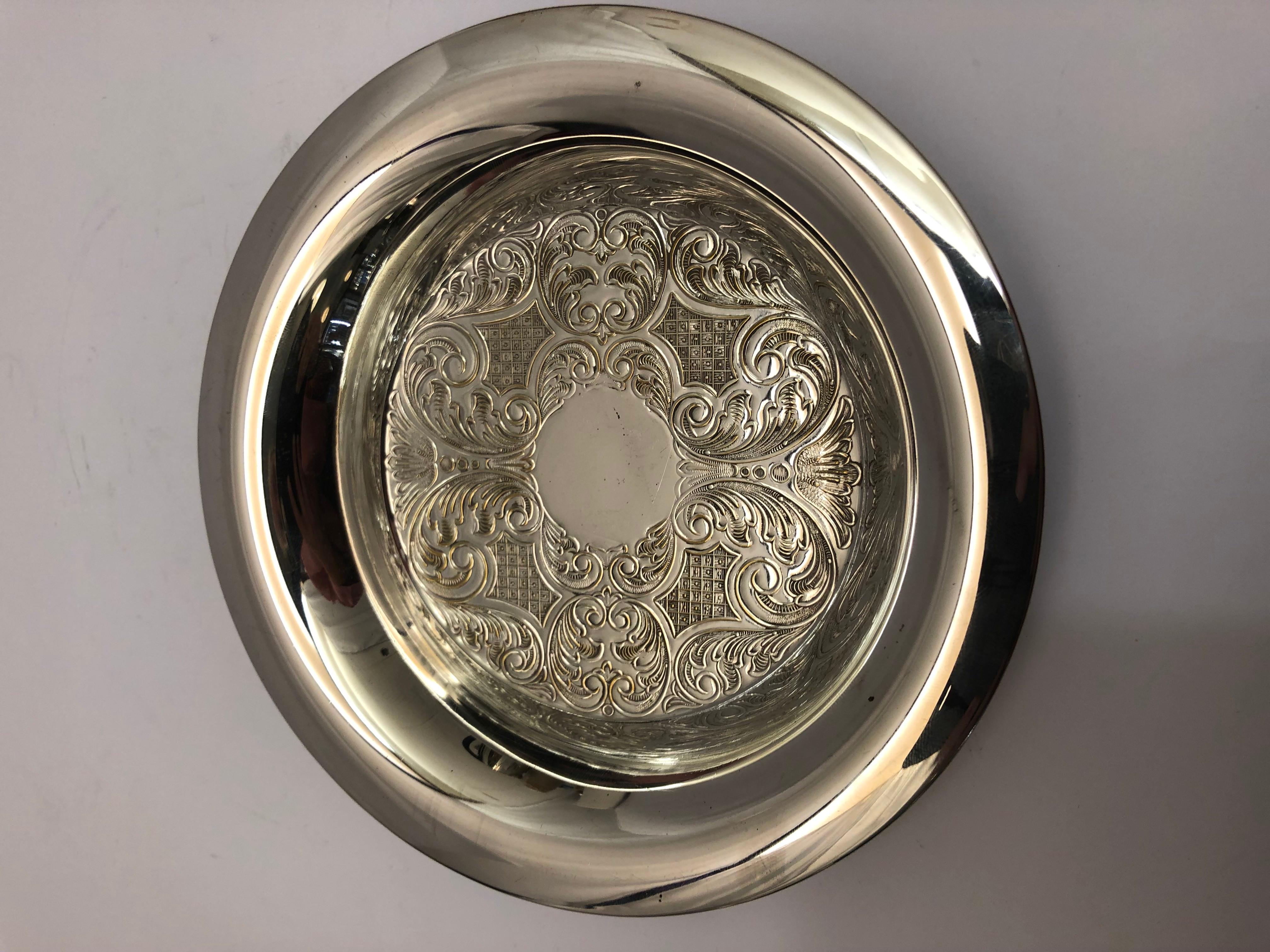 Silver plate circular dish with embossed decoration & a broad rim, English, circa 1920.