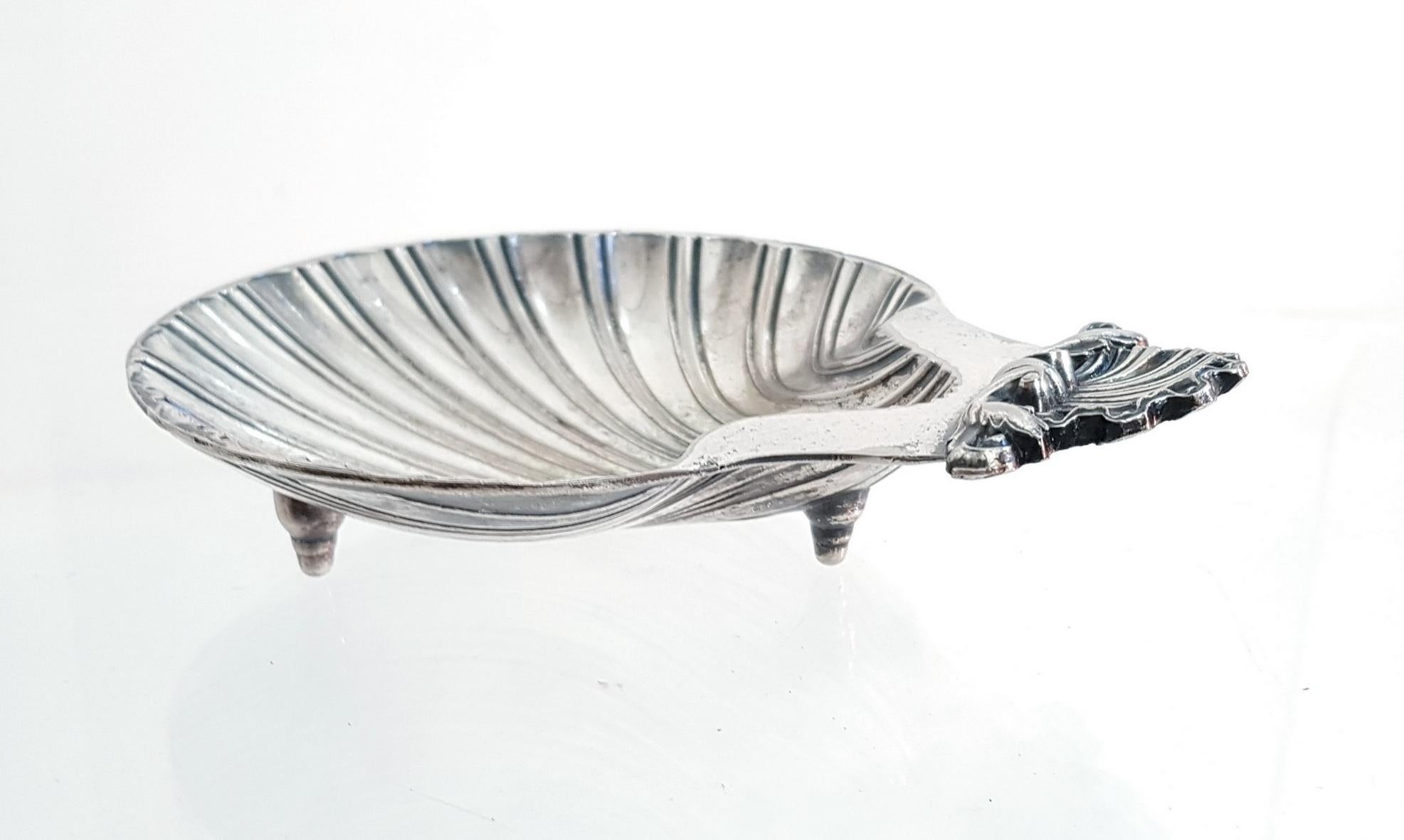 Cute footed clam dish in silver plate. Reproduction from an original design from the 18th century. This particular piece is made in the USA and has clear stamps underneath. This is perfect as a soap dish, ashtray or for snacks.
